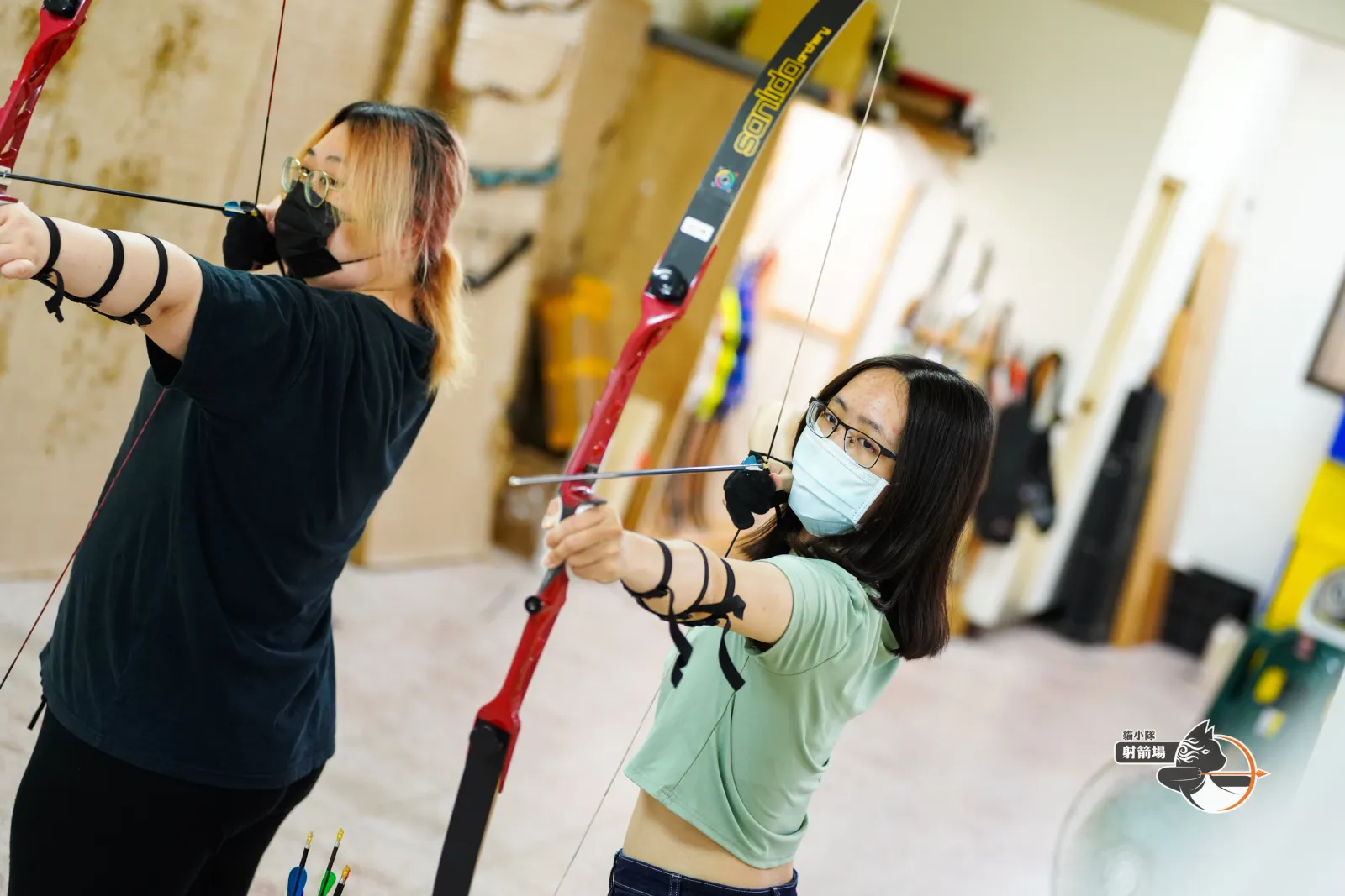 教練在射道旁示範新手射箭動作